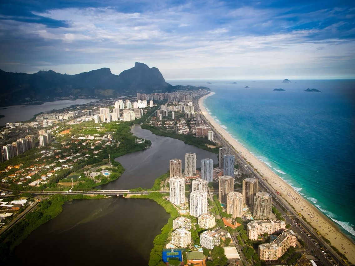 Extensa faixa de areia e mar turquesa na Barra da Tijuca, Rio de Janeiro.