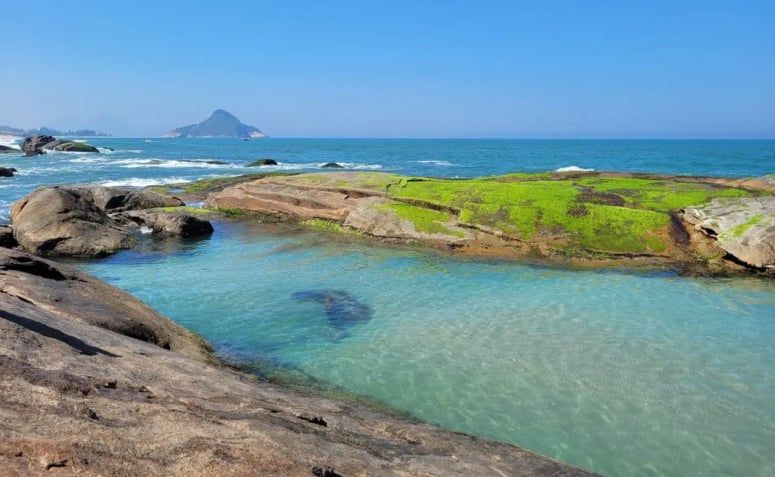 Piscina natural da Praia do Secreto cercada por paredões rochosos.