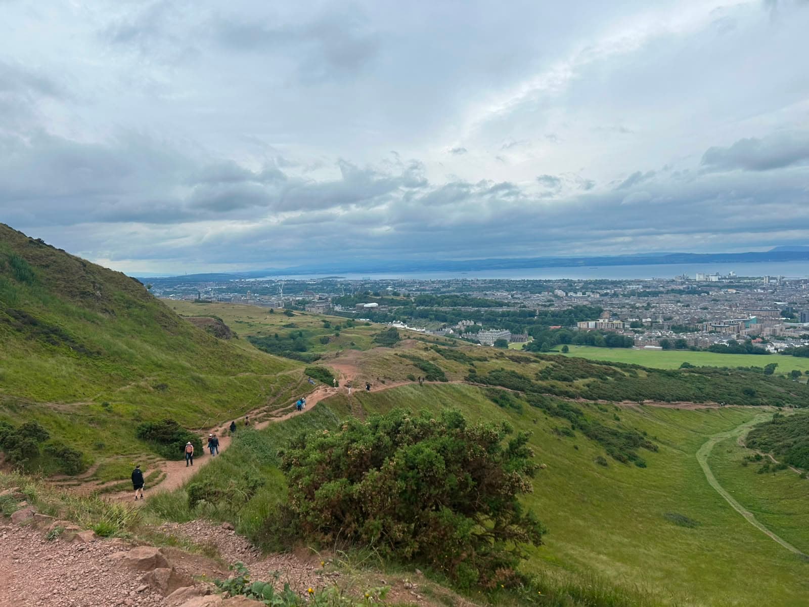 Camino hacia Arthur’s Seat y vista panorámica de la ciudad de Edimburgo de fondo.