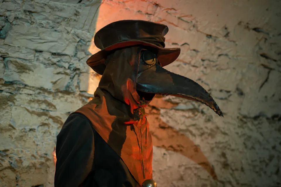 Historical recreation of Doctor George Rae with his bird-beak mask and black leather robes in the underground alleys of Edinburgh, Scotland.