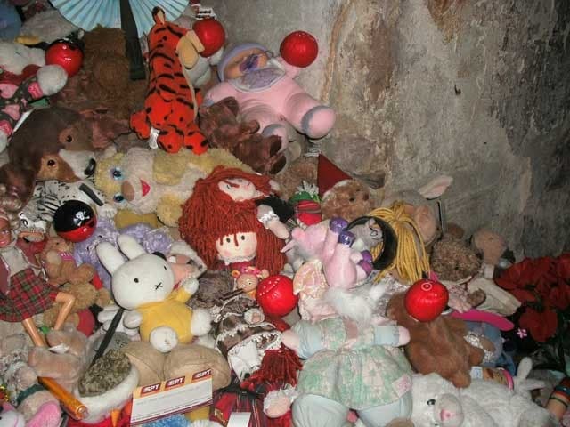 The corner of Annie's room filled with teddy bears, dolls, and toys left by visitors at The Real Mary King's Close.