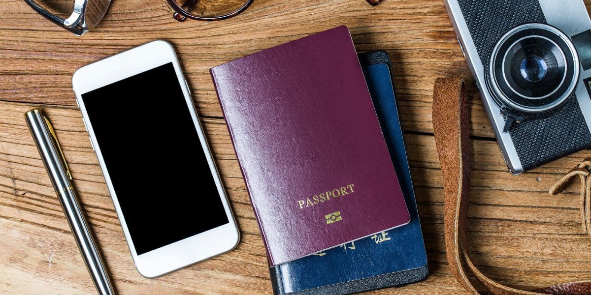 Passport, phone, and card on a table before traveling