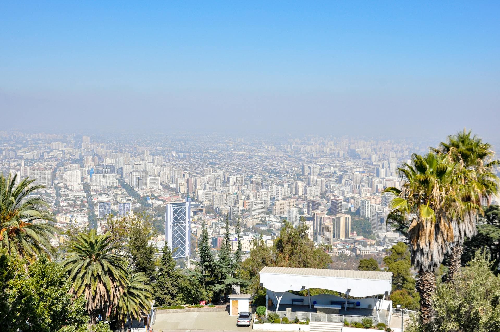 Una vista panorámica de Santiago de Chile desde el Cerro San Cristóbal, con el perfil de la ciudad y palmeras.