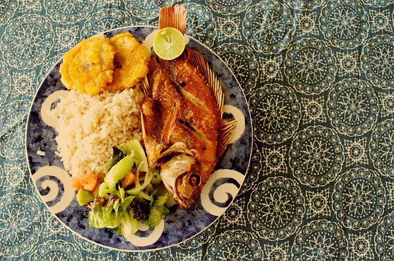 Typical dish of Isla Barú and Cartagena de Indias: fried red snapper with coconut rice, patacones, and salad.