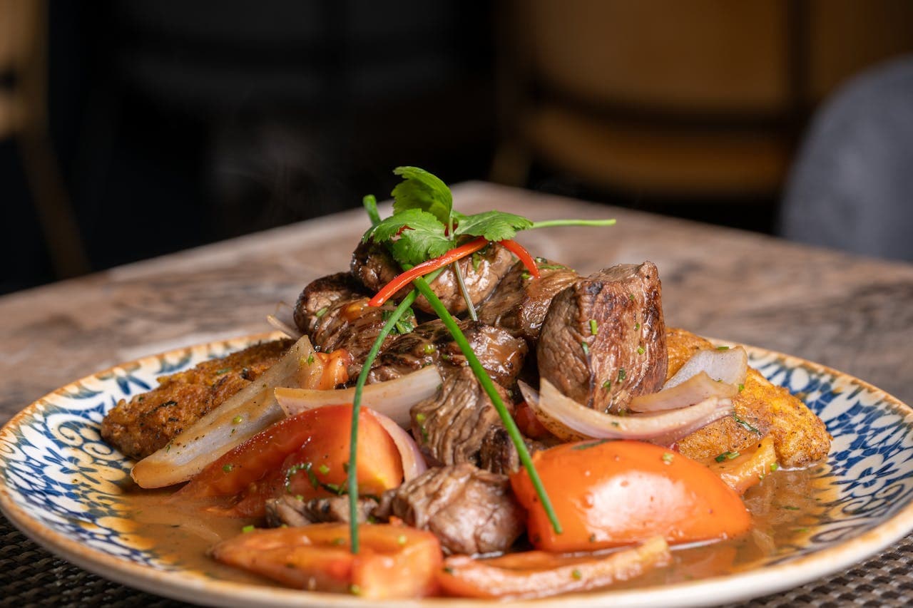 Lomo Saltado is one of the most emblematic dishes of Peruvian gastronomy, born in the 19th century from the fusion between local Creole cuisine and the stir-fry technique in a wok introduced by Chinese-Cantonese immigrants.