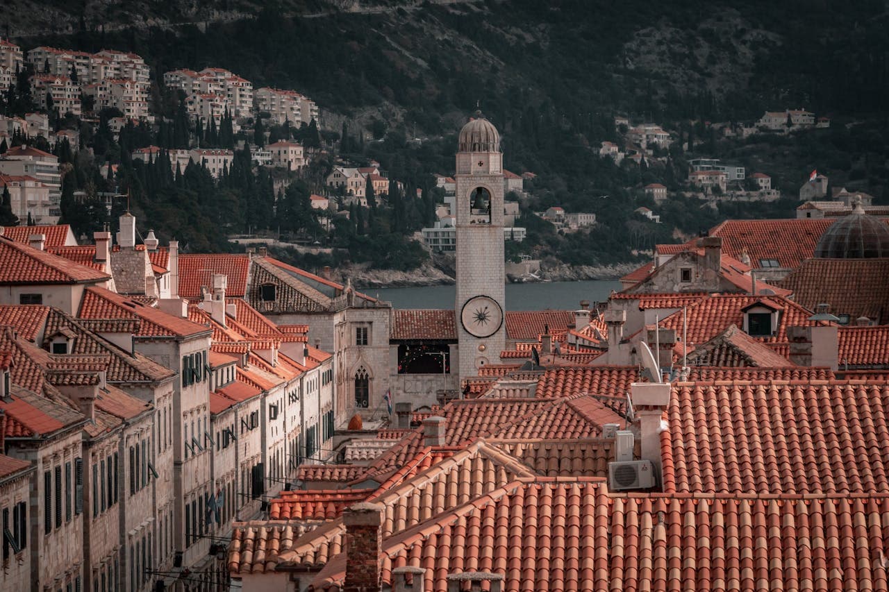 Stone and forest postcards. The Old Town bell tower stands out against the Adriatic horizon and the vast green expanse of Mount Srđ.