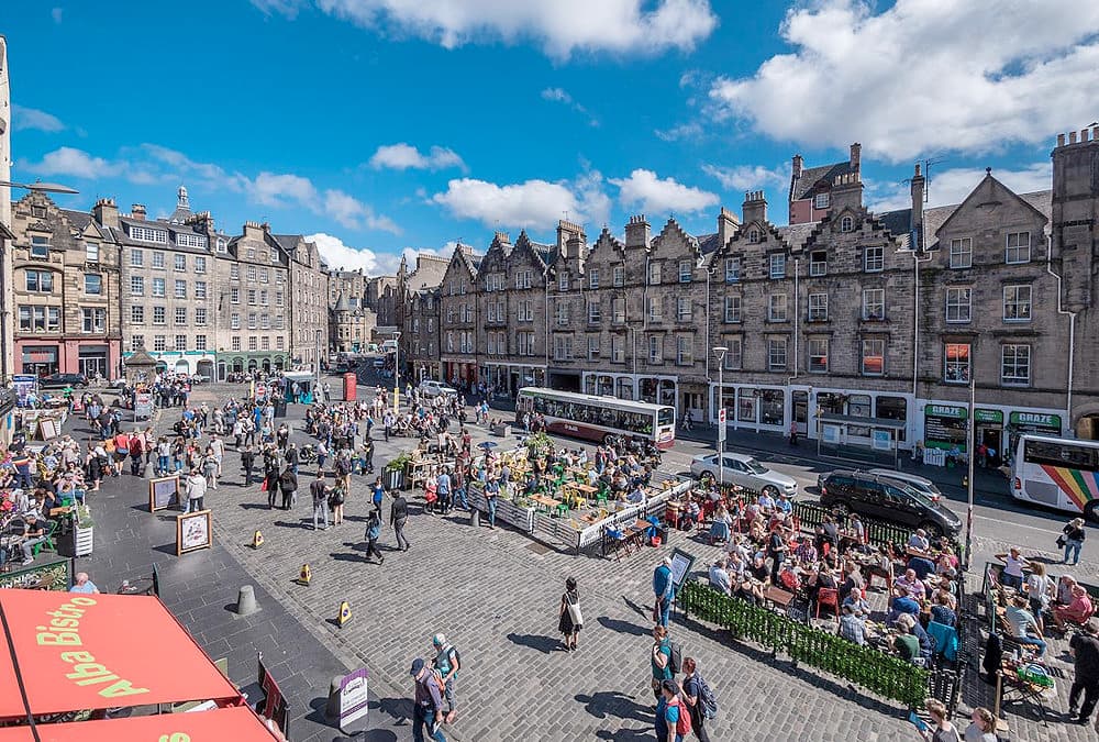 Vista panorámica de la plaza de Grassmarket con sus coloridas fachadas de tiendas y pubs, en Edimburgo, Escocia.