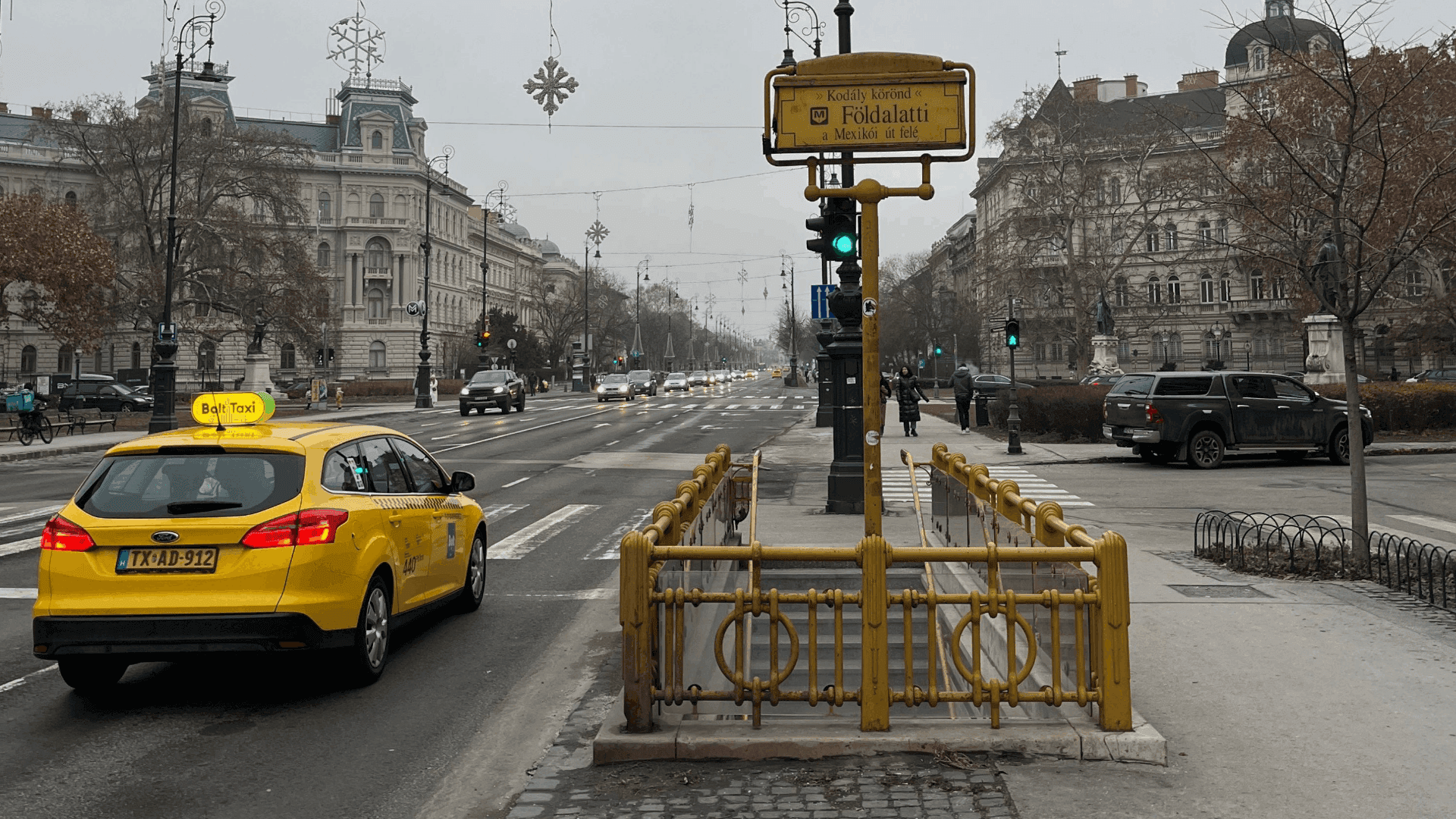 Urban street in Hungary with elegant buildings, historic architecture, and wide sidewalks.