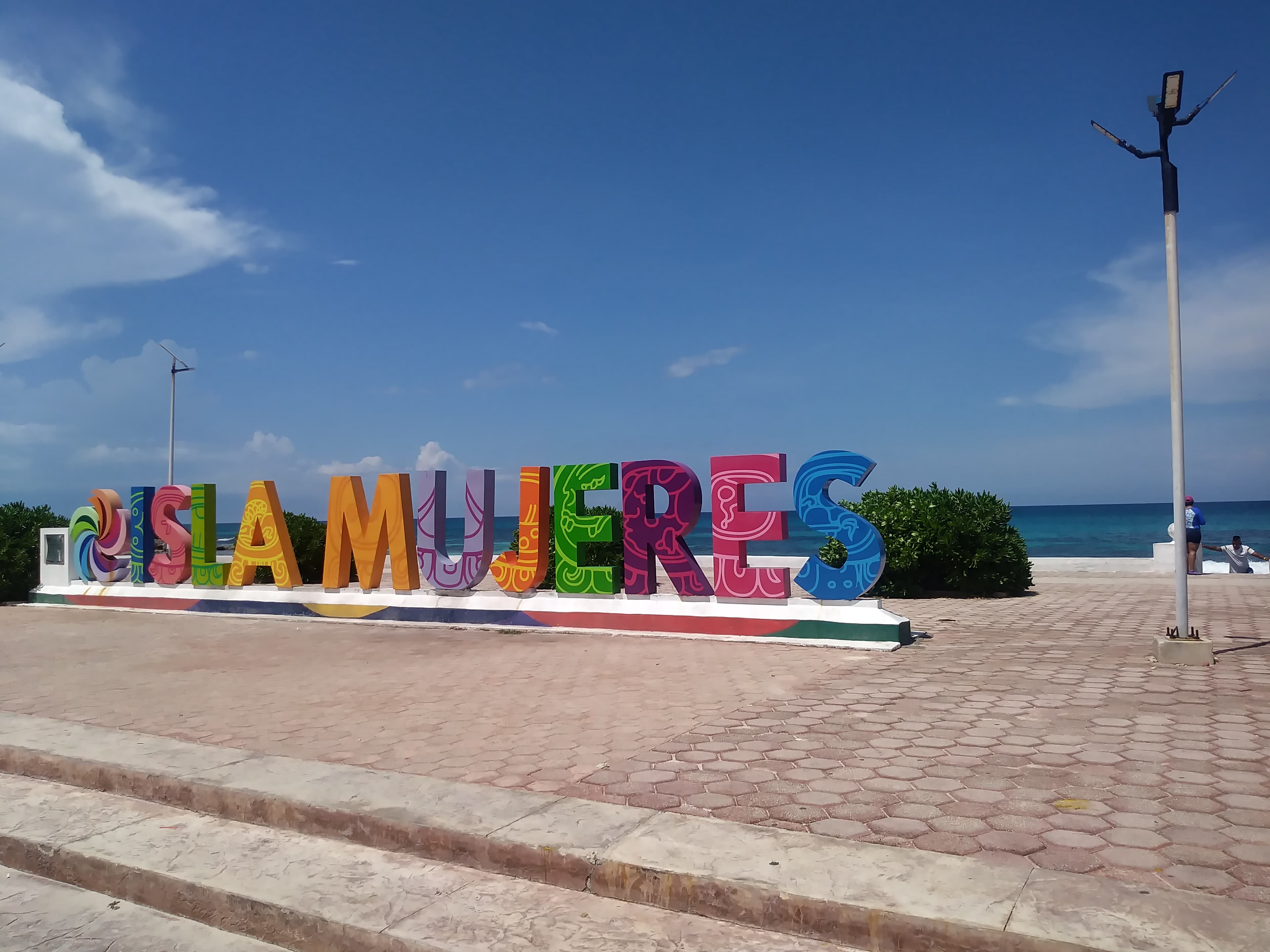 Sea view of Playa Norte in Isla Mujeres with turquoise water and palm trees.