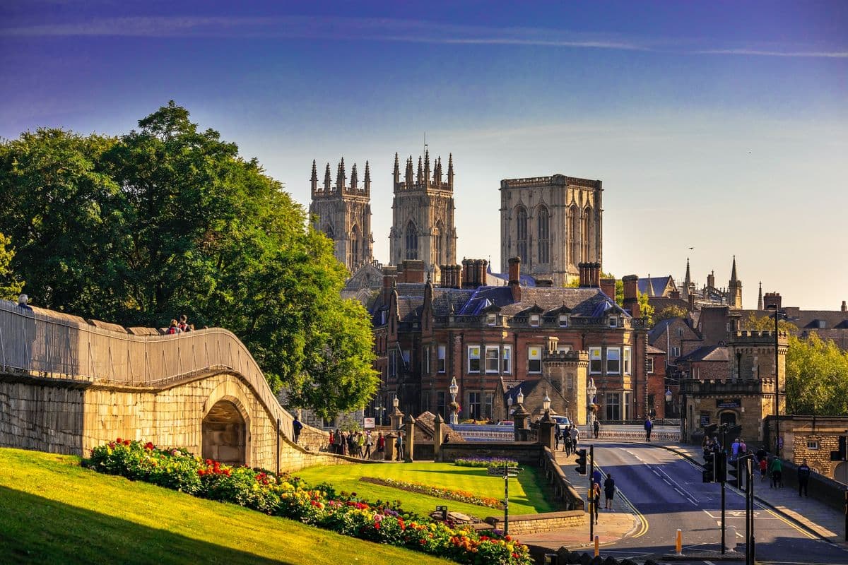 Captura de la Catedral de York con murallas históricas de la ciudad y una vibrante escena callejera en York, Inglaterra.