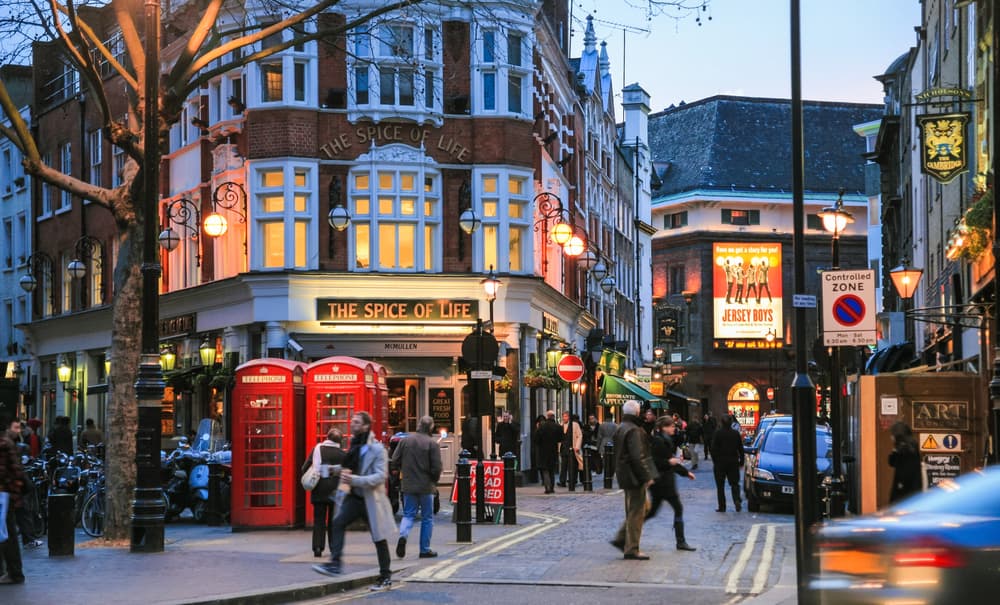 Vista de un paseo por Soho, un barrio moderno de Londres, lleno de comercios alrededor.