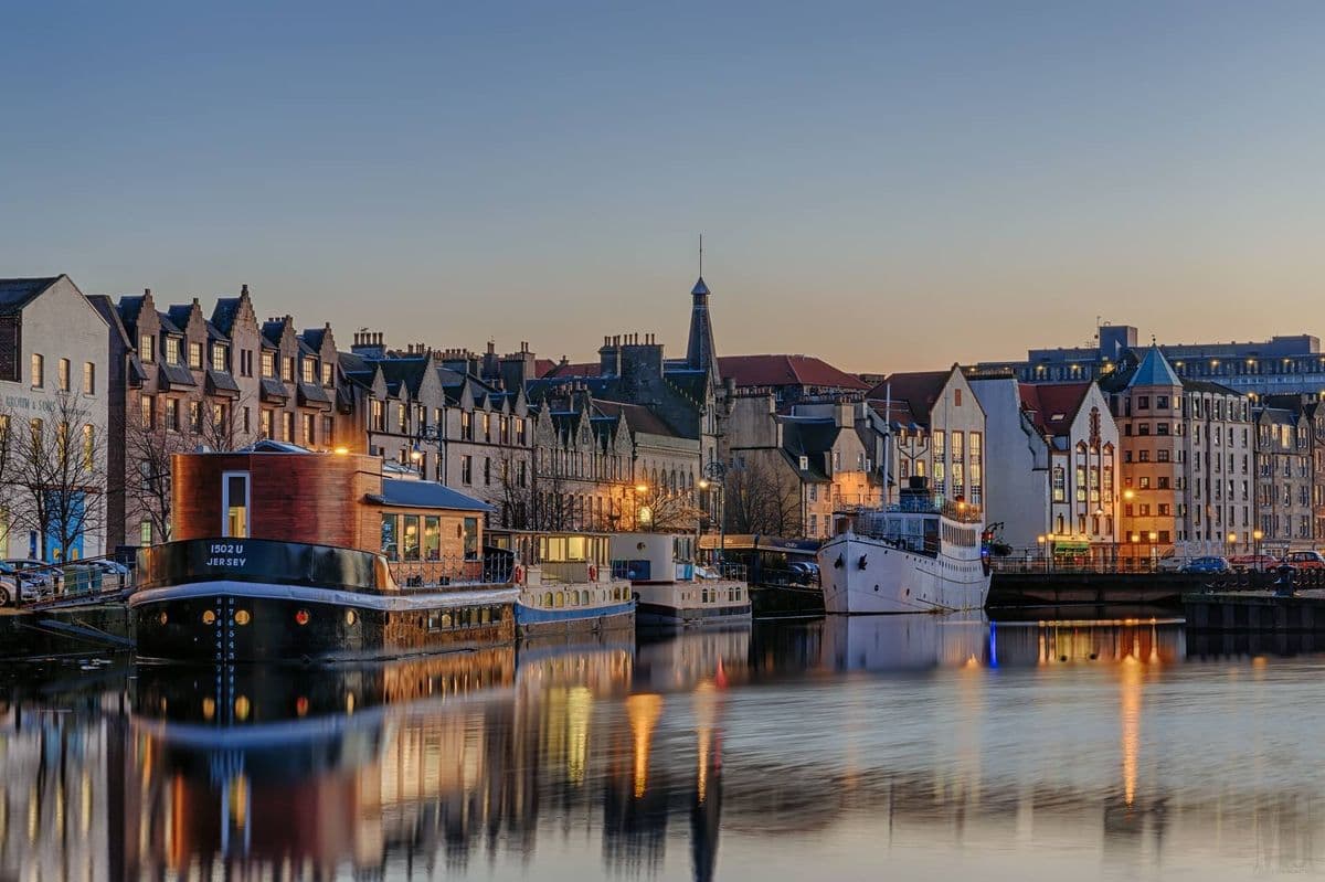 Vista panorámica del canal de Leith (The Shore) con reflejos en el agua y edificios históricos al atardecer. Edimburgo, Escocia.