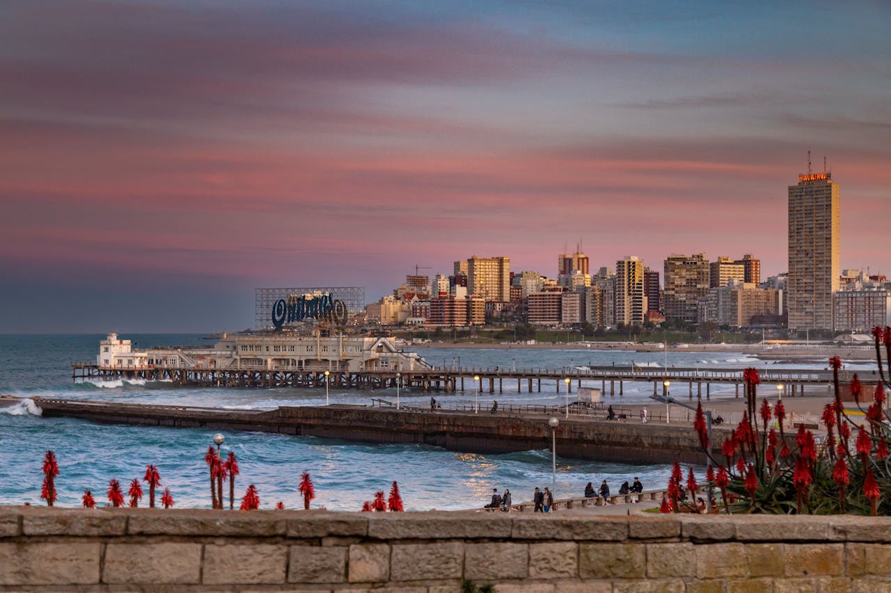Ubicada en la zona de La Perla, esta icónica estructura de hormigón que se interna en el mar es el refugio histórico de los aficionados a la pesca deportiva. Su cartel luminoso de Quilmes es un emblema nocturno de la costa, ideal para caminar sobre las olas y capturar una de las vistas más clásicas del skyline marplatense.