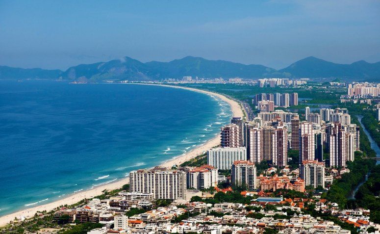 Vista panorámica de la inmensa franja de arena blanca y el mar turquesa de Barra da Tijuca en Río de Janeiro, Brasil.