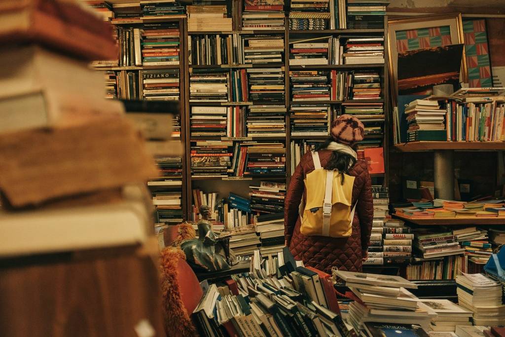 Interior e mesas de ofertas de uma livraria noturna clássica na Avenida Corrientes.