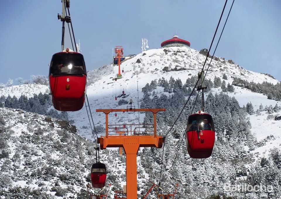 The famous red gondolas of the Cerro Otto Cable Car ascending towards the summit.
