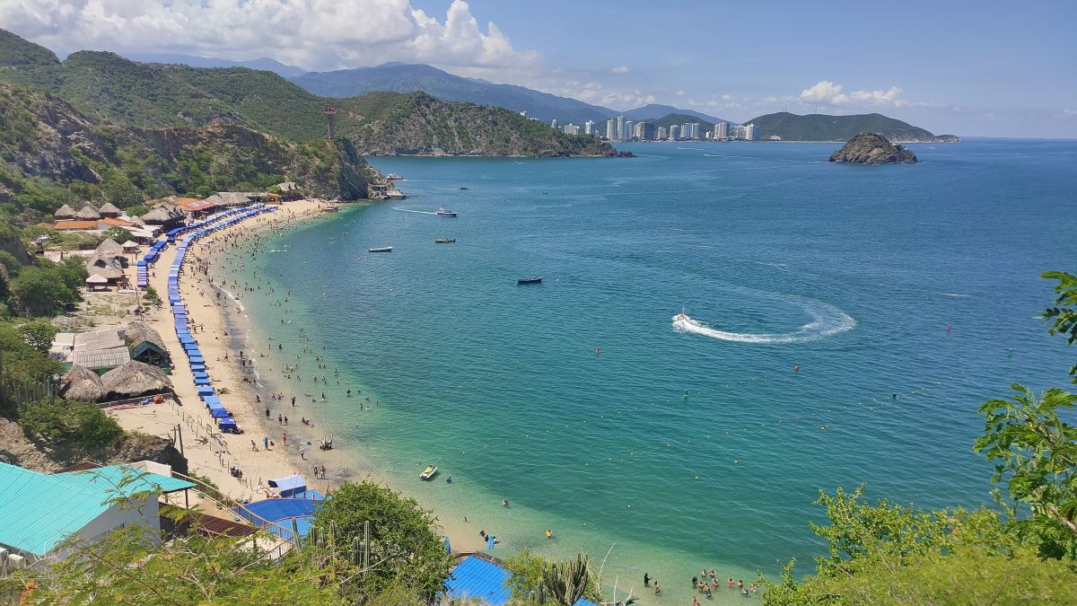 Playa Blanca en Santa Marta Colombia vista desde el mar con cerros áridos y aguas cristalinas.