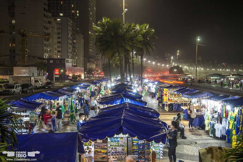 Puestos iluminados de la Feirinha Noturna de artesanos en la Avenida Atlântica de Copacabana.