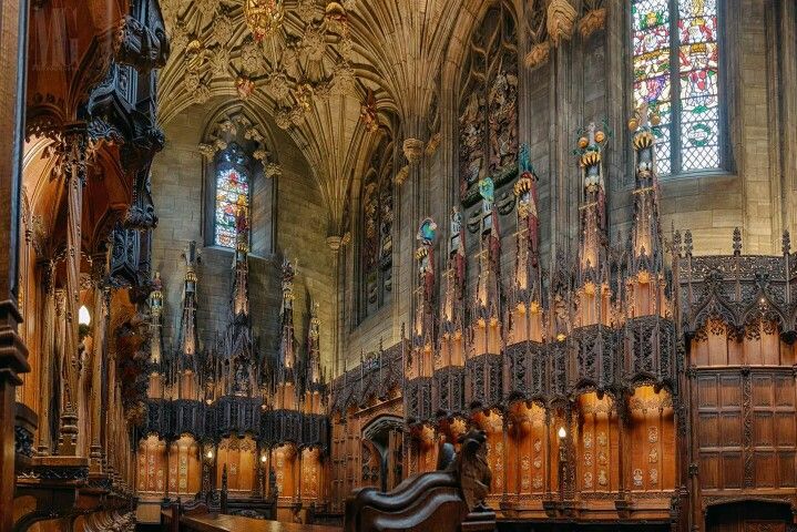 Tetos abobadados azuis e vitrais góticos iluminando o interior histórico da Catedral de St Giles, Edimburgo, Escócia.