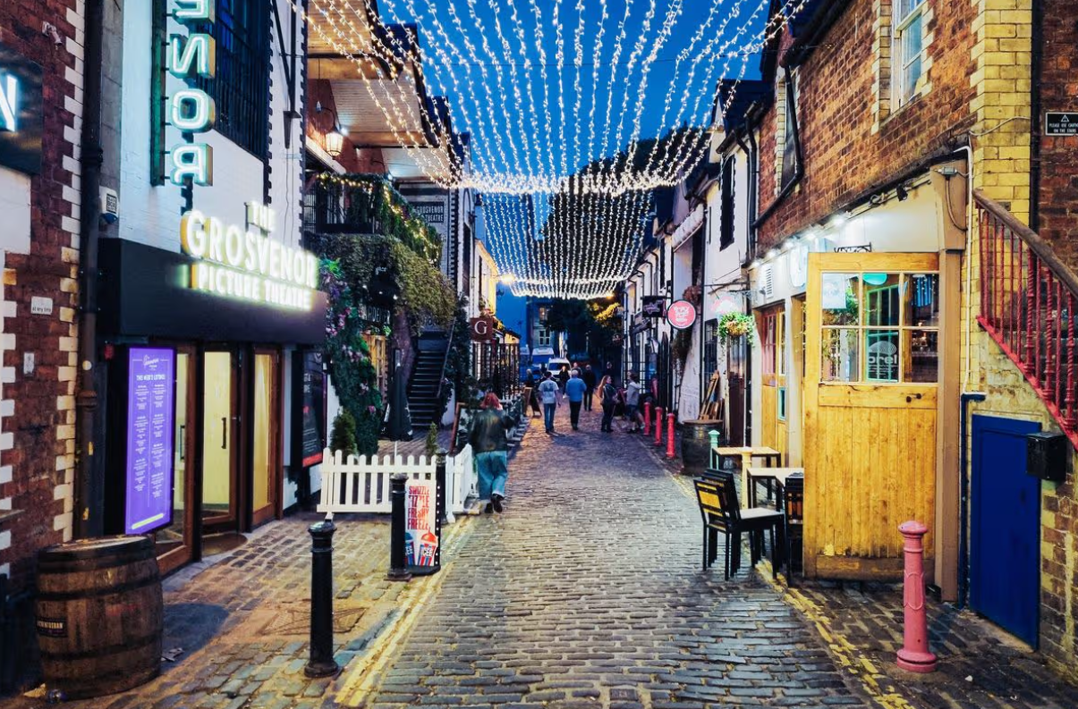 Ashton Lane en el West End de Glasgow, una calle empedrada llena de encanto, luces y pubs tradicionales.