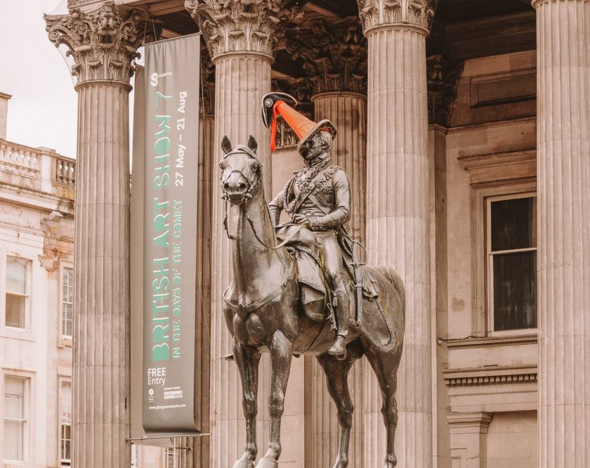 Detalhe da estátua do Duque de Wellington com o icônico cone de trânsito laranja e branco na cabeça.