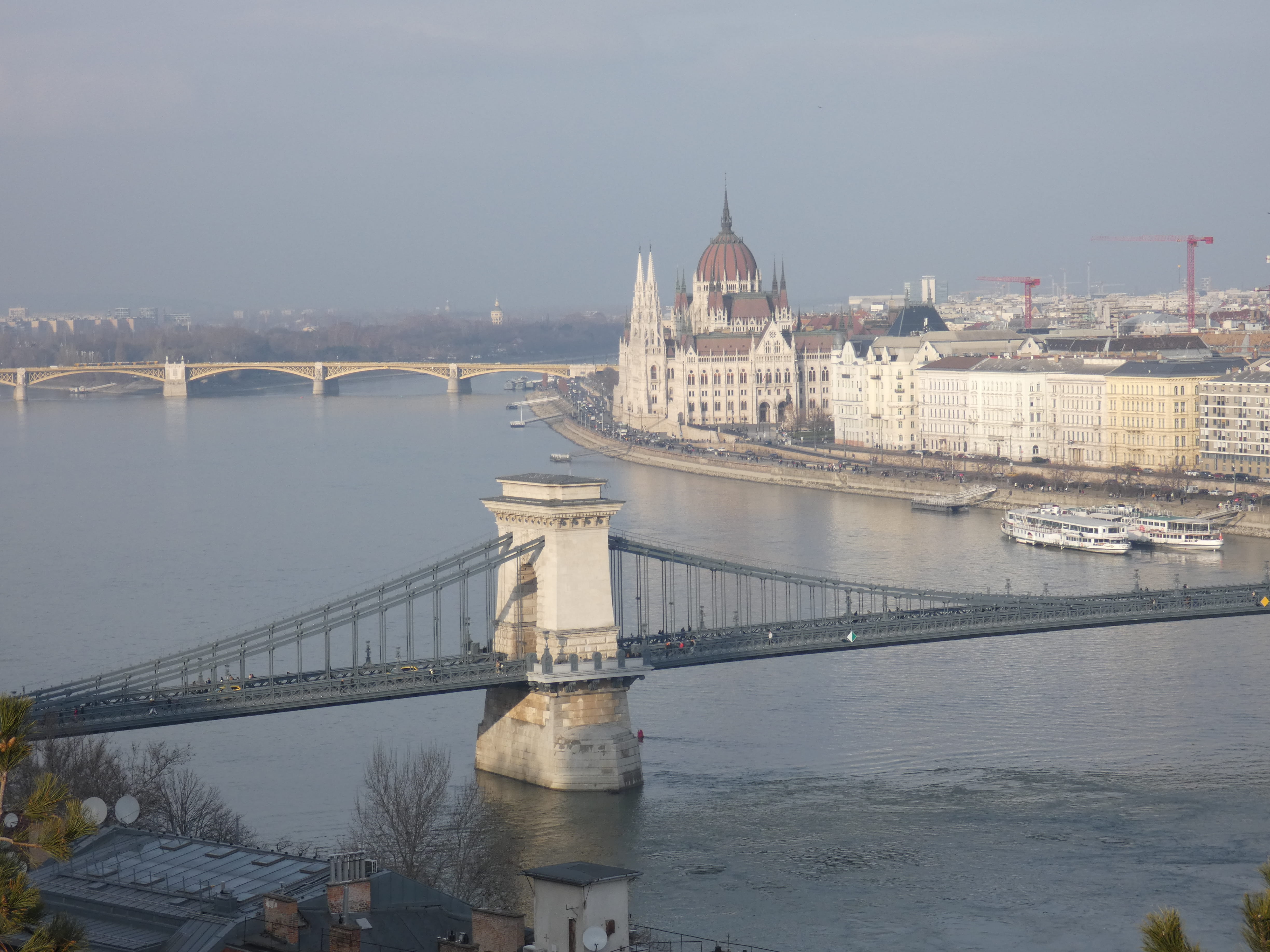 El Parlamento de Budapest iluminado al atardecer desde el río Danubio.