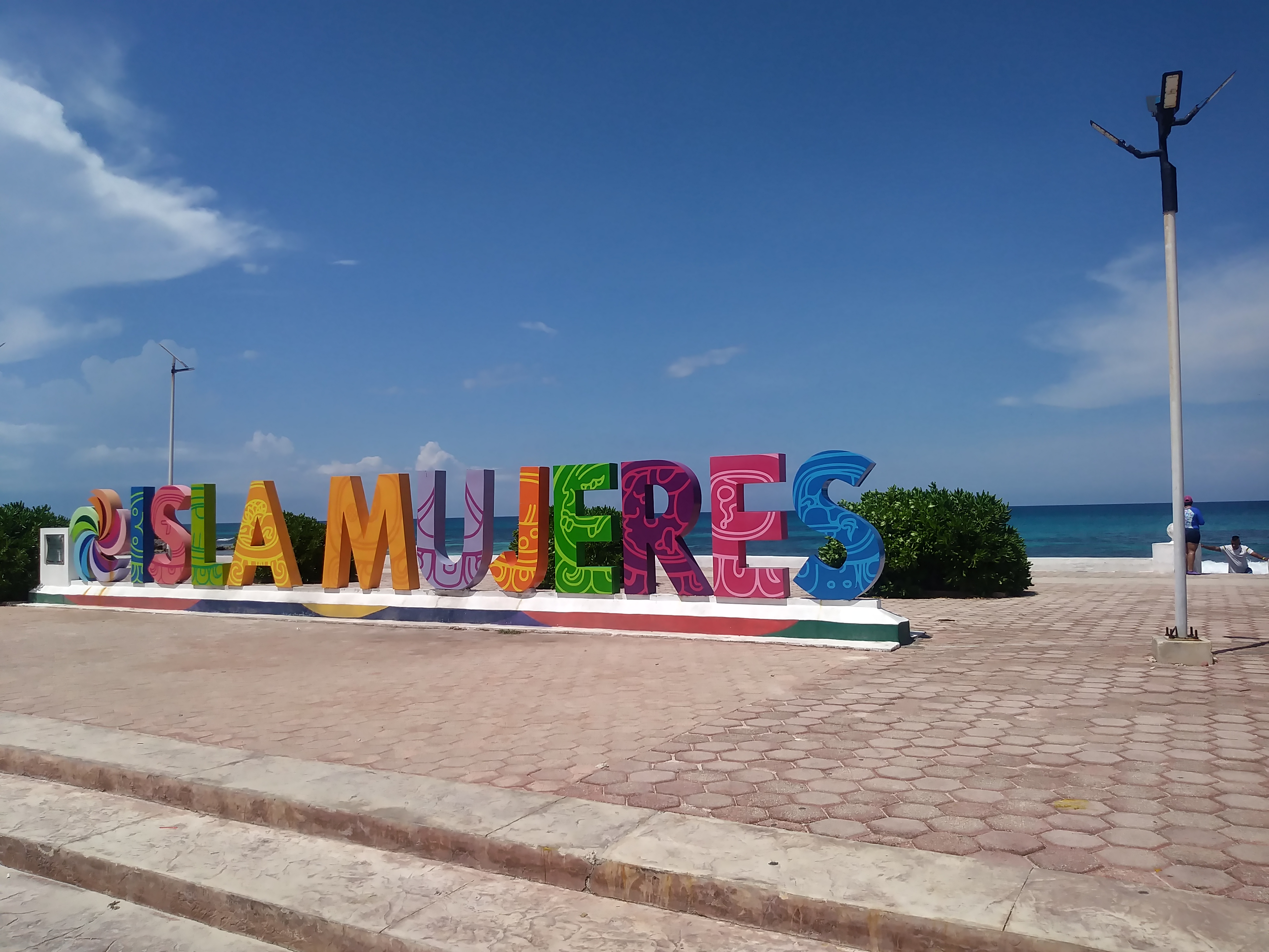 Vista desde el mar de Playa Norte en Isla Mujeres con agua turquesa y palmeras.