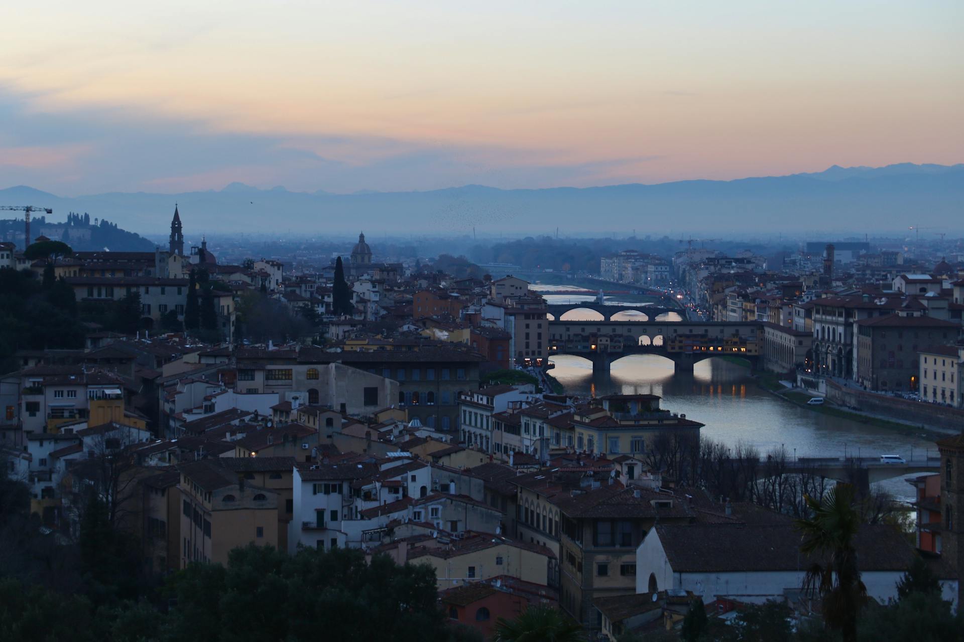 Una hermosa vista del atardecer de Florencia, Italia, con el emblemático Ponte Vecchio y el río Arno.