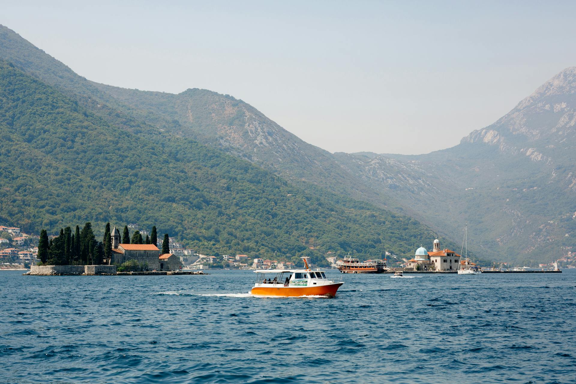 Crucero en barco cerca de Nuestra Señora de las Rocas y la isla de San Jorge en la bahía de Kotor de Montenegro.