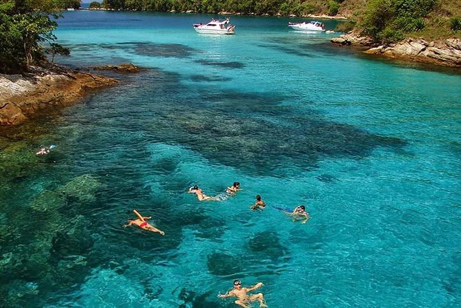 Turistas haciendo snorkel en las aguas turquesas de Lagoa Azul en Ilha Grande, Brasil.