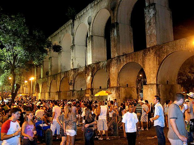 Vista de los icónicos Arcos da Lapa iluminados al caer la noche en Río de Janeiro.