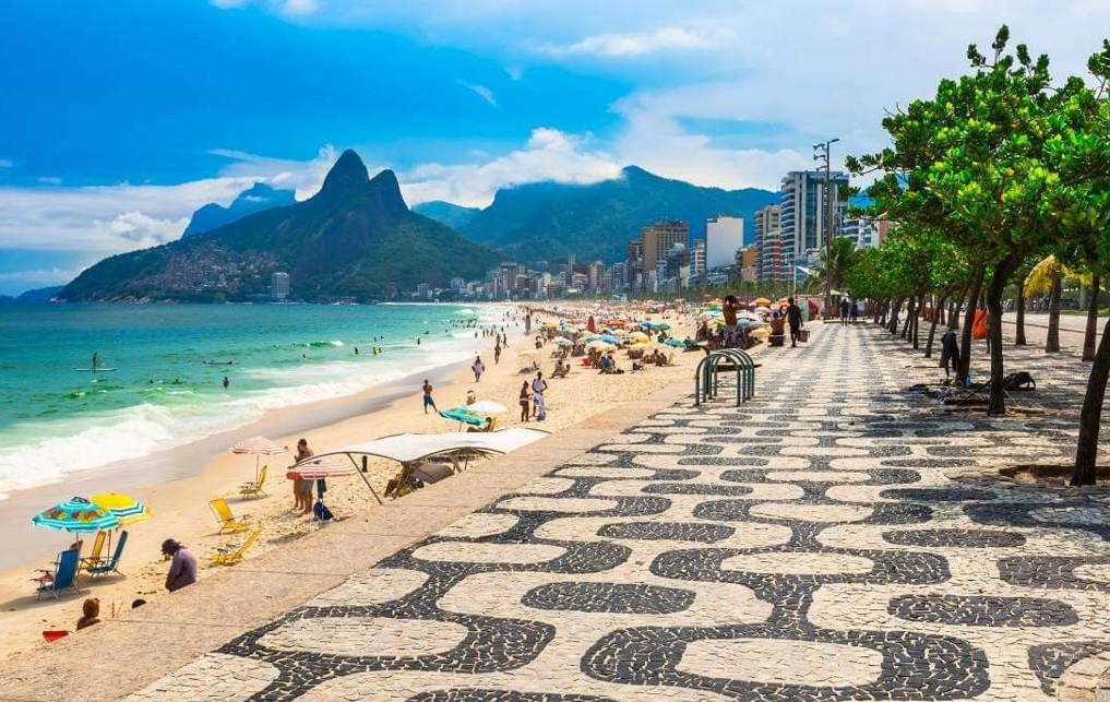 Calçadão do Leblon com seu mosaico característico e o Morro Dois Irmãos ao fundo.