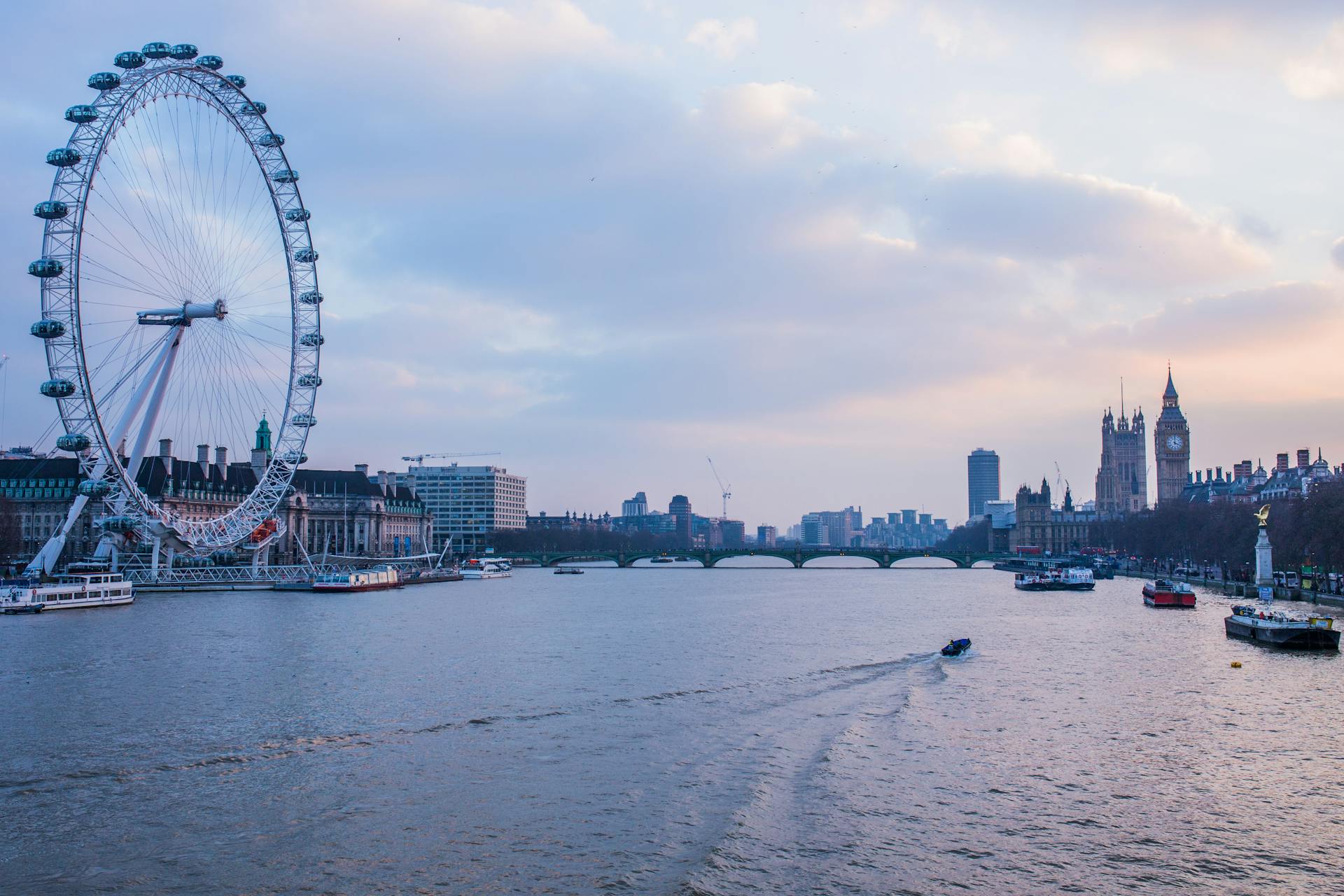 Panoramic view of Westminster Bridge, Big Ben, and the London Eye over the River Thames.