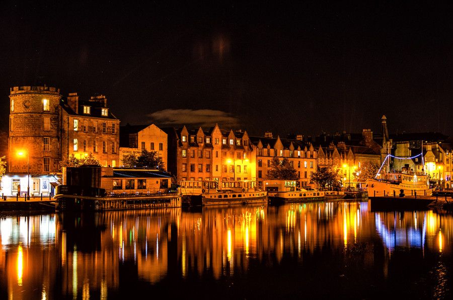 O Canal de Leith iluminado à noite em Edimburgo, Escócia.