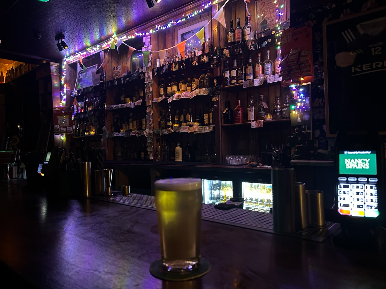Ambiente animado de un pub tradicional inglés con canillas de cerveza artesanal local, y música en vivo en Manchester, Inglaterra.