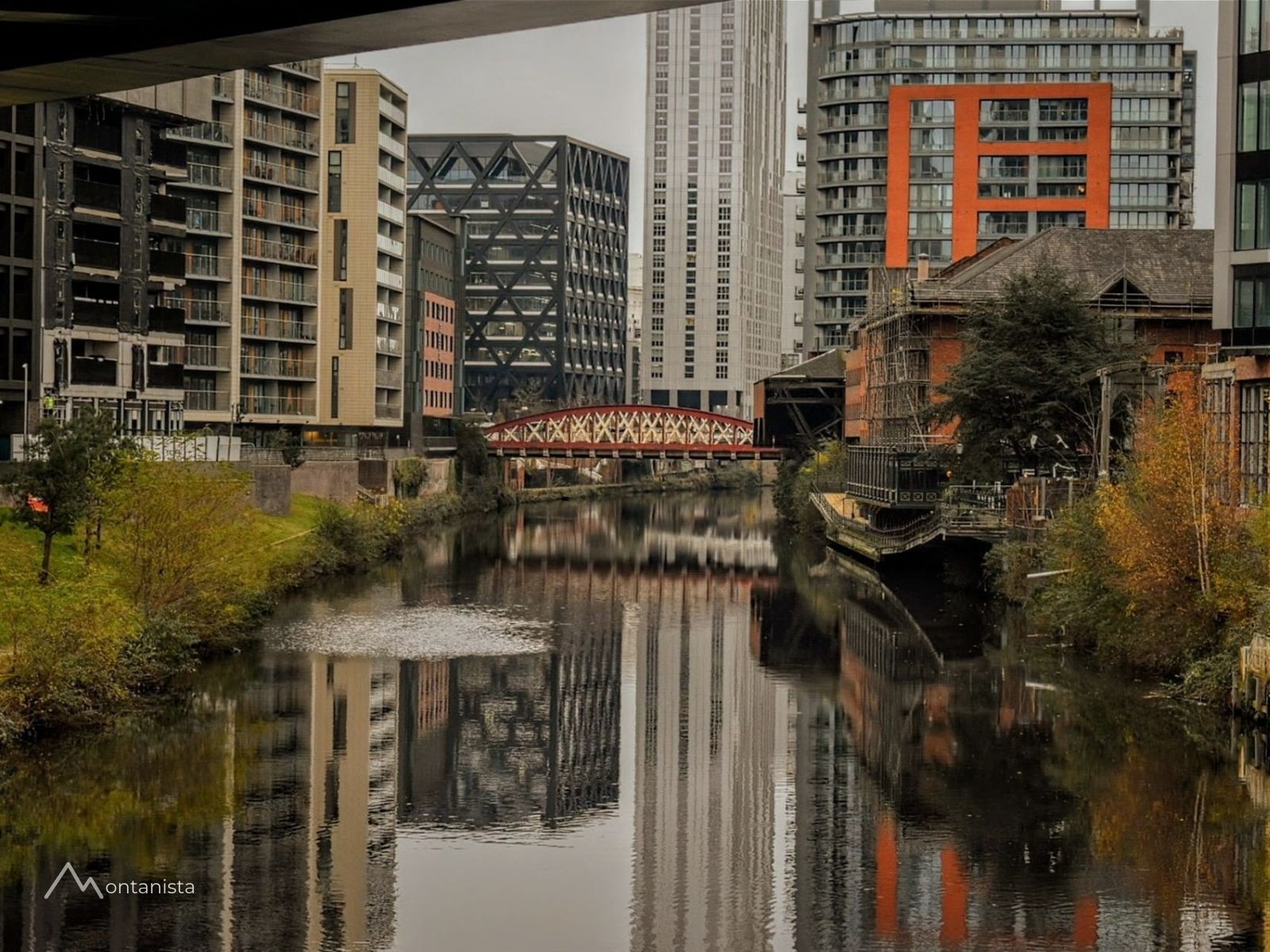 Canales de Castlefield cruzados por puentes de hierro históricos y rodeados de almacenes industriales restaurados en Manchester.