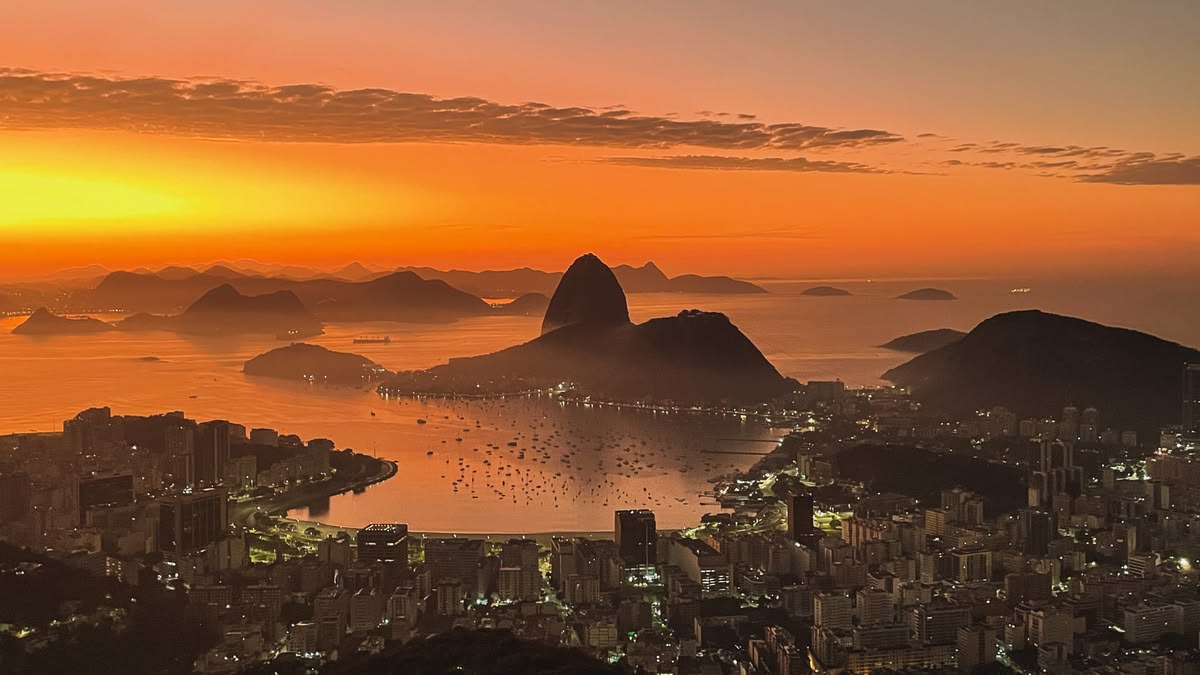 Vista panorámica desde el Mirante Dona Marta hacia el Pan de Azúcar y la Bahía de Guanabara al atardecer en Río de Janeiro.