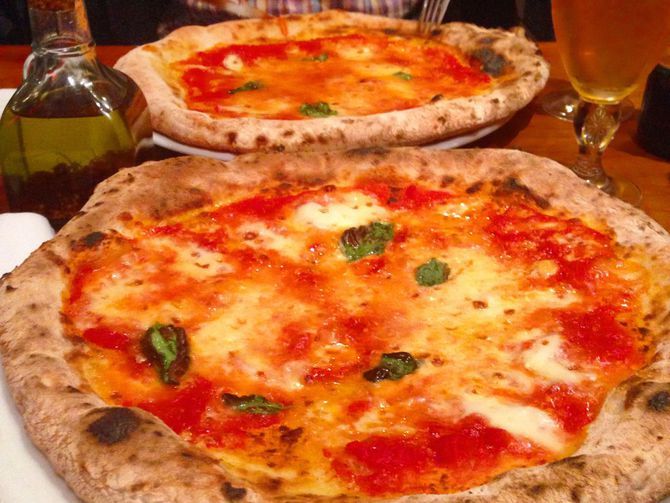 Pizza de molde com queijo derretido abundante em uma pizzaria tradicional de Buenos Aires.