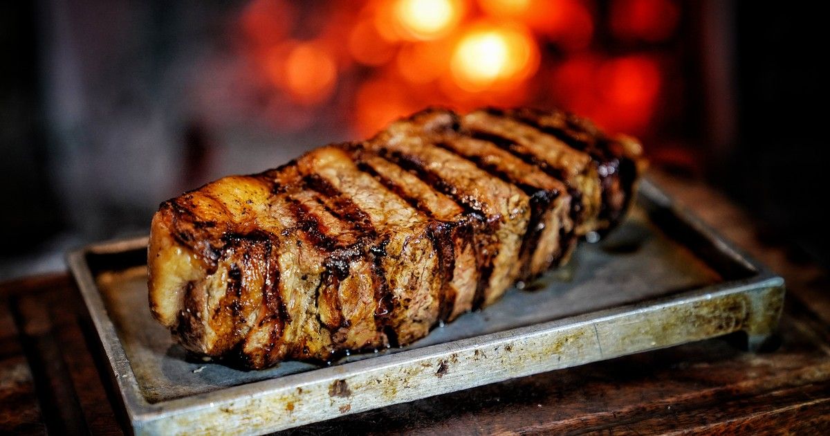 Corte de ancho (ojo de bife) na parrilla com brasas de lenha em Buenos Aires.
