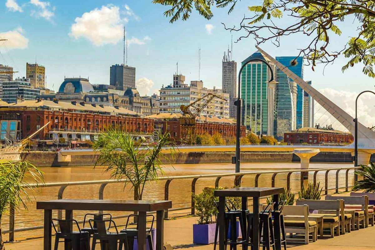 Mesas de restaurante con vista al Puente de la Mujer en Puerto Madero, Buenos Aires.