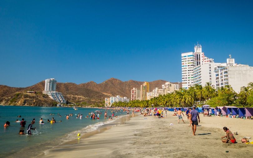 Playa El Rodadero en Santa Marta Colombia con edificios frente al mar y palmeras.