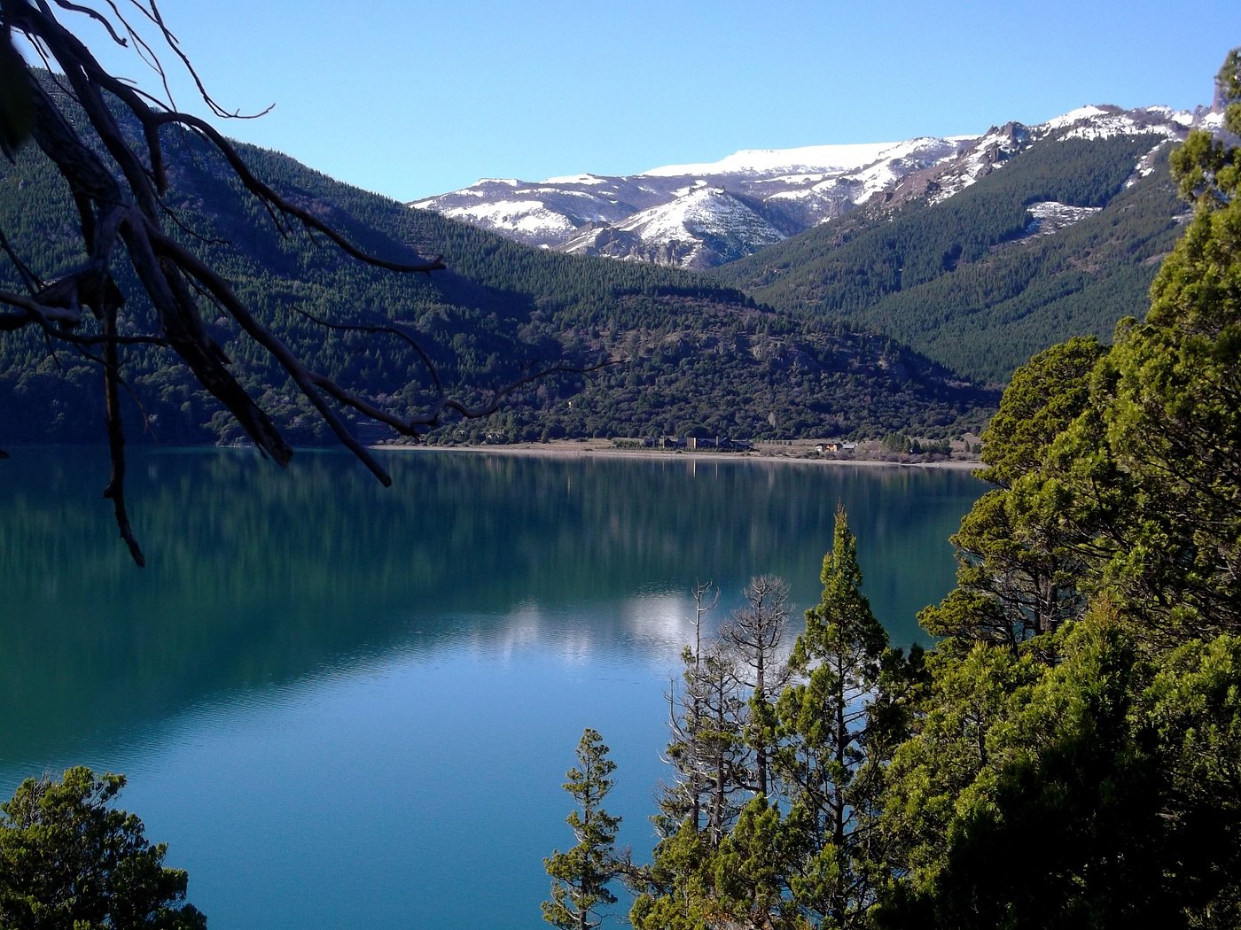 Quiet waters of Lake Meliquina surrounded by pine trees and Patagonian peaks a short drive from San Martín de los Andes.