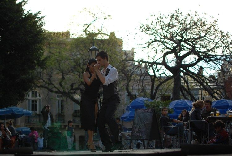 Pareja bailando tango al aire libre en la Plaza Dorrego del barrio de San Telmo, Buenos Aires.
