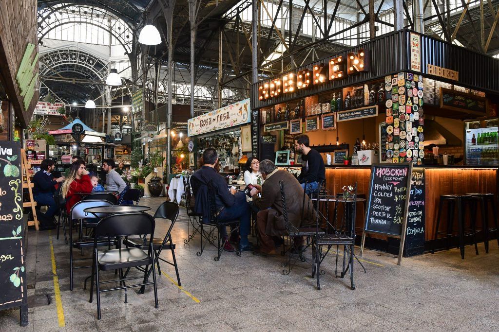 Interior del emblemático Mercado de San Telmo con puestos gastronómicos y estructura de hierro.