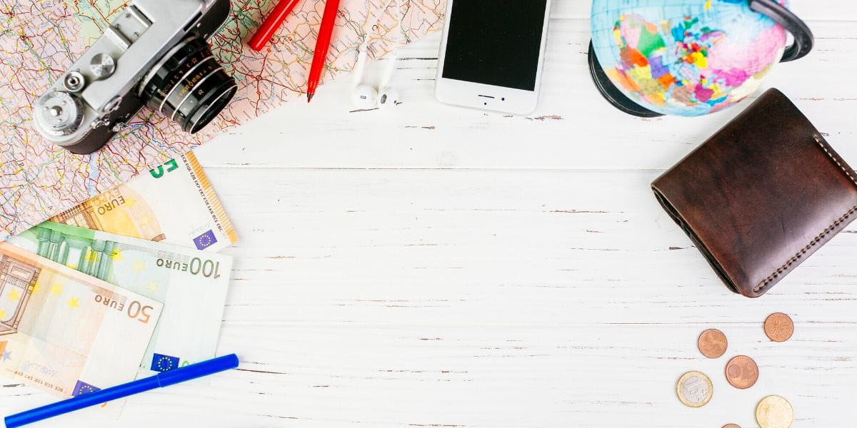 Cuaderno con presupuesto de viaje, calculadora y mapas