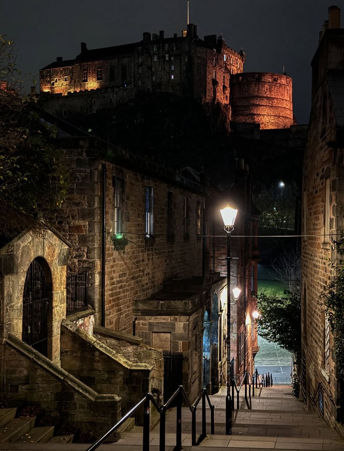 Vista noturna do Castelo de Edimburgo a partir da parte alta de The Vennel.